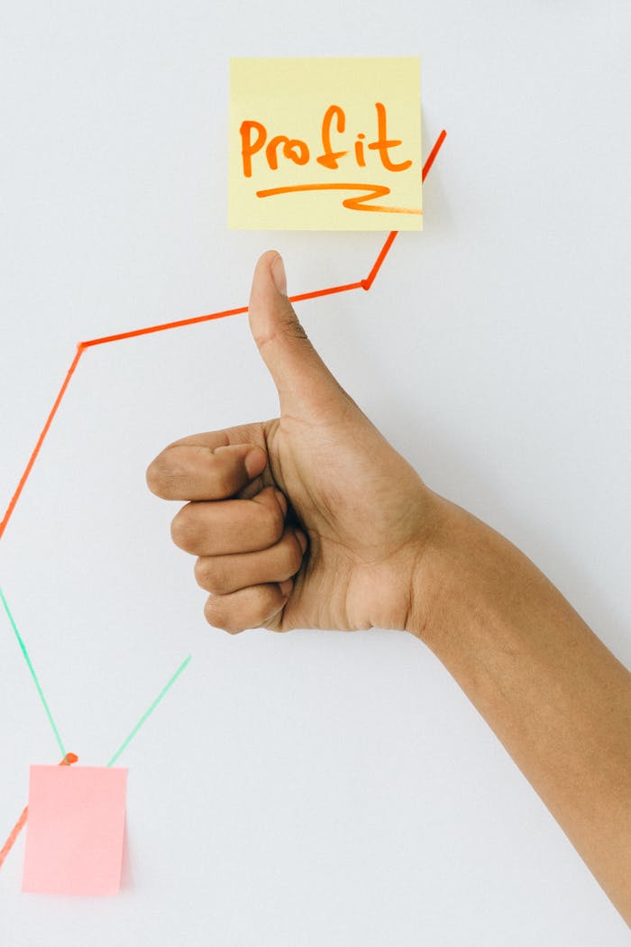 creative-01 A hand giving a thumbs up in front of a profit growth chart, highlighting success.